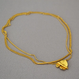 Macro detail of gold plated brass double layer necklace with abstract fluid pendant