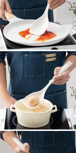 Silicone spatula and soup spoon used for cooking in a non-stick pan, modern kitchen scene