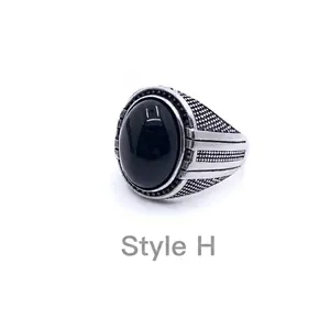 Detailed macro shot of vintage mens ring featuring black gemstone and silver textured metal