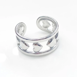 Detailed view of silver open ring featuring a hollow heart pattern and polished finish