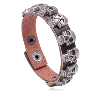 Men's punk leather bracelet featuring five vintage metal skulls with snap button closures
