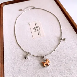 Collier vintage avec pendentif cheval à bascule en bois, chaîne argentée et cloches