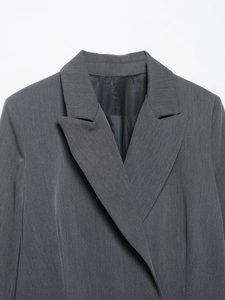 Détail d'un blazer business gris foncé avec revers à cran et texture de tissu raffinée