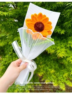 Close-up of handmade pipe cleaner sunflower bouquet with mesh wrap and pearl ribbon