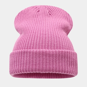 Gros plan du bonnet rose en maille côtelée montrant la texture épaisse et le revers large