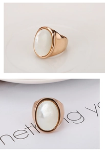 Detail of rose gold stainless steel ring featuring a large oval white shell inlay