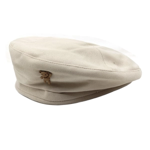 Close-up of beige wool beret featuring a cute brown bear ornament and neat stitching