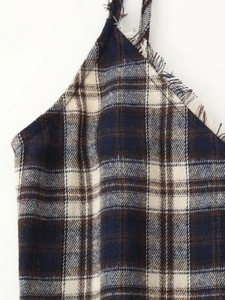 Detailed close-up of plaid dress neckline with frayed fringe edges and textured fabric