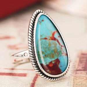 Detalle macro de anillo de turquesa en forma de gota con borde de cuerda de plata