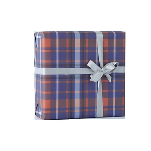 Elegant gift box with orange and purple plaid wrapping paper and shiny silver ribbon bow