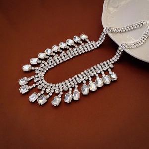 Detailed close-up of a luxury silver-toned necklace with square crystals and cascading fringe