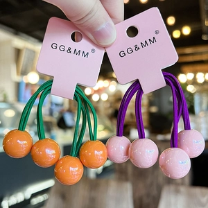Close-up of colorful ponytail holders with contrasting round beads on pink display cards