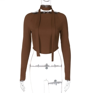 Dettaglio del crop top marrone in maglia a coste con scollo a sciarpa e maniche lunghe
