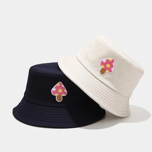 Detail of navy and beige cotton bucket hats featuring cute mushroom embroidery
