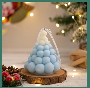 Detailed view of blue and white gradient Christmas tree candle with a FOR YOU ribbon