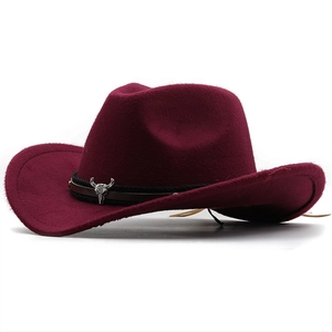 Détail d'un chapeau de cow-boy en feutre bordeaux avec emblème tête de taureau