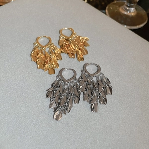 Detailed view of layered leaf fringe tassels on gold and silver hoop earrings