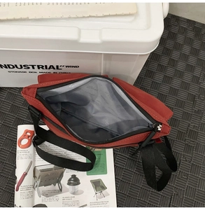 Detail view of red nylon messenger bag interior with gray lining and multiple compartments