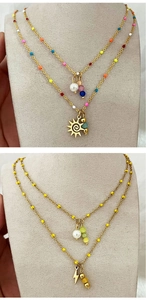 Detail of double-layered gold star and lightning pendants with colorful enamel beads