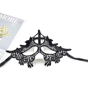 Detail of elegant black lace embroidery mask with silk ribbons on a magazine background
