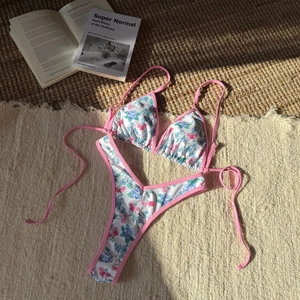 Two-piece floral bikini set with triangle tie top and high cut bottoms on resort rug