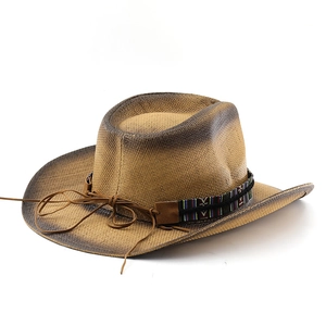 Detailed view of woven straw cowboy hat featuring ethnic pattern band and leather trim