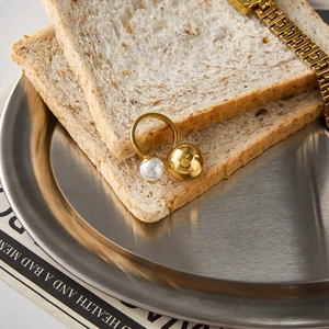 18K gold plated stainless steel open ring with pearls on a decorative steel plate