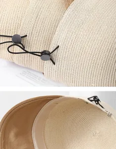Detail of beige straw sun hat showing fine weave texture and adjustable black drawstring buckle