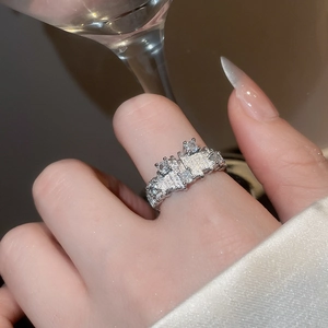 Macro detail of irregular silver texture and clear zircons on minimalist open ring