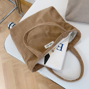 Close-up of brown corduroy tote bag with white inner lining and simple wish label