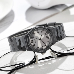 Grey camouflage quartz watch for kids with round dial on a white surface with glasses