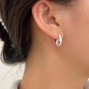 Sleek 925 sterling silver hoop earrings with minimalist polished finish on a model