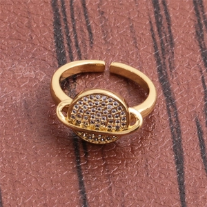 Elegant gold celestial planet open ring with sparkling cubic zirconia on brown leather