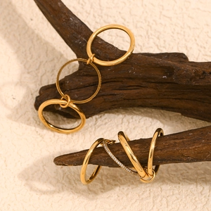 Macro detail of 18K gold-plated four-layer layered ring with micro-set stones on wood
