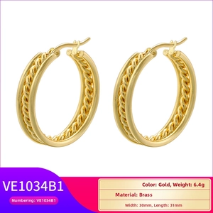 Detail of gold plated brass hoop earrings with smooth mirror and twisted rope texture