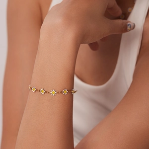 Close-up of a 18k gold plated stainless steel daisy chain bracelet on a female wrist