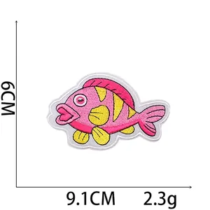 Detail of pink fish embroidered patch with yellow fins and precise size measurements