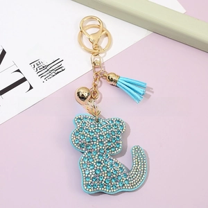 Detail of light blue rhinestone cat keychain with leather tassel and gold lobster clasp