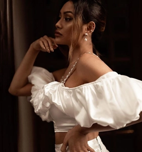 Detail of white satin two-piece set with pearl straps and elegant pleated cropped top