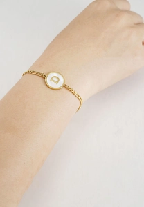 Detail of 18K gold stainless steel bracelet with white shell charm featuring letter D