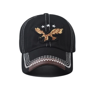 Dettaglio del ricamo dell'aquila dorata e delle stelle su un cappello da baseball nero
