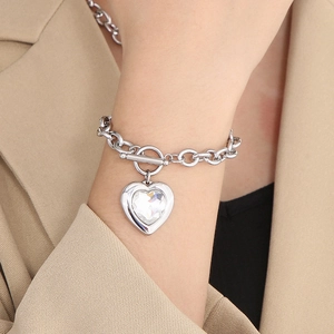 Detail of silver chain bracelet with heart pendant and crystal on model's wrist