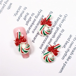 Nahaufnahme von rot-grün gestreiften Zuckerstangen-Anhängern für festliche Weihnachts-Nagelkunst