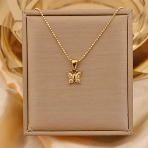 Close-up of golden butterfly pendant with sparkling cubic zirconia on gold bead chain