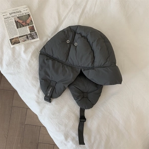 Detail of dark grey quilted windproof trapper hat with adjustable strap and air vents