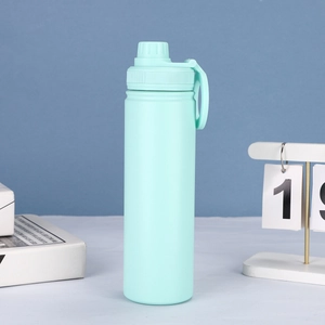 Close-up of a light blue insulated sports bottle with a magnetic cap on a white table