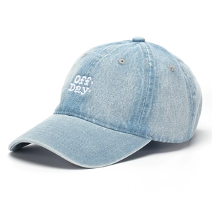 Detail shot of Off Day embroidery on washed blue denim baseball cap with six-panel design
