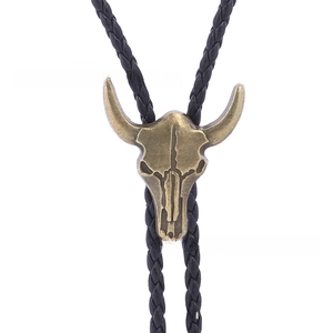Close-up of vintage bronze longhorn skull pendant on a black braided leather bolo tie