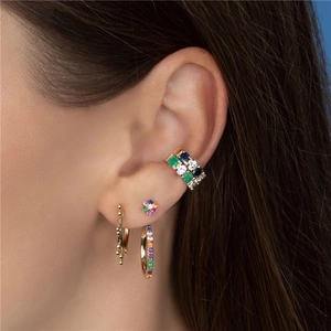 Detail shot of a model wearing a gold ear cuff and rainbow zircon flower stud earrings