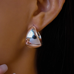 Close-up of minimalist silver water drop earrings with a polished mirror finish on model